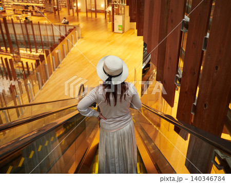 富山図書館のエスカレーターに乗る若い女性の姿 富山図書館のエスカレーターに乗る若い女性の姿 140346784