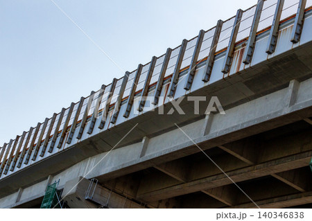 青空を背景にアオリのアングルで捉えたコンクリート製の高速道路高架橋 140346838