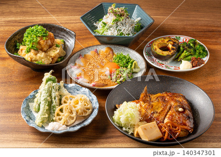 居酒屋のテーブルに並ぶ多彩な一品料理の盛り合わせ 居酒屋のテーブルに並ぶ多彩な一品料理の盛り合わせ 140347301