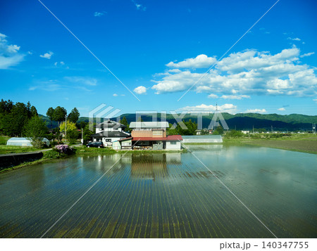 春の長野県の安曇野市の美しい水田と農家の風景 春の長野県の安曇野市の美しい水田と農家の風景 140347755