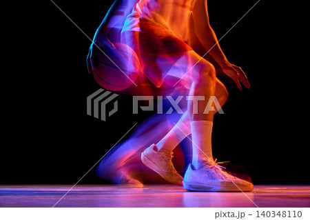 Close basketball dribble detail with neon motion blur on black background. Close basketball dribble detail with neon motion blur on black background. 140348110