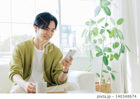 リビングでスマホを見る男性 リビングでスマホを見る男性 140348674