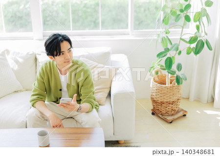 リビングでスマホを見る男性 リビングでスマホを見る男性 140348681
