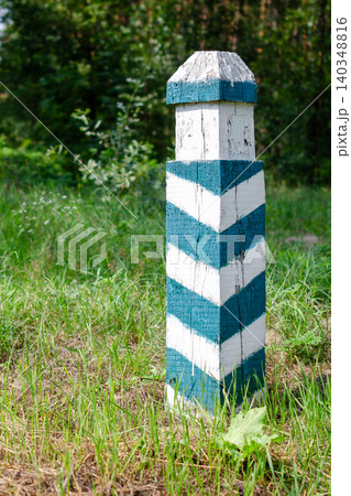 Boundary marker post in forest property line and demarcation concept wooden pillar with green and white stripes in nature. Boundary marker post in forest property line and demarcation concept wooden pillar with green and white stripes in nature. 140348816