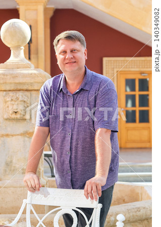 A portrait of a Russian tourist standing in an open-air Italian restaurant in a charming European town 140349082