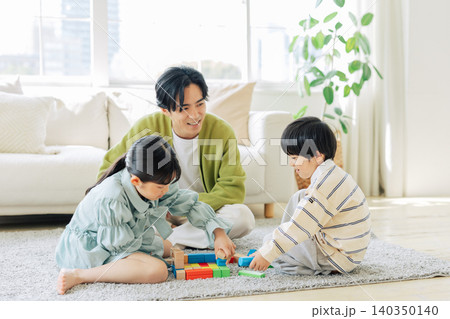 積み木で遊ぶ子供と見守るお父さん 積み木で遊ぶ子供と見守るお父さん 140350140