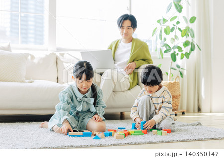 積み木で遊ぶ子供と見守るお父さん 積み木で遊ぶ子供と見守るお父さん 140350147