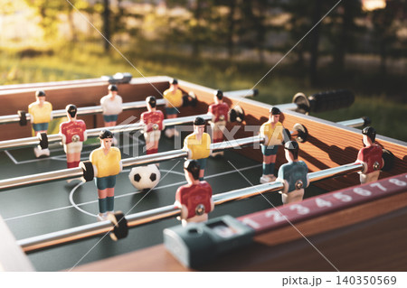 Foosball table with red white and yellow blue plastic soccer players, expressing connecting to worldwide football Foosball table with red white and yellow blue plastic soccer players, expressing connecting to worldwide football 140350569