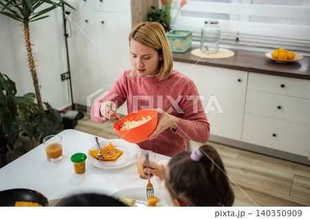 Mother and child enjoying healthy meal together in kitchen 140350909