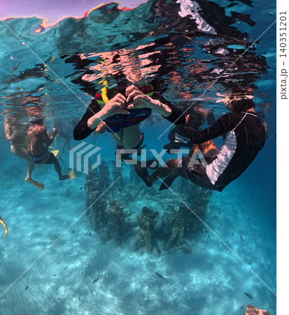 Snorkelers explore a circle of underwater sculptures in clear tropical waters. Snorkelers explore a circle of underwater sculptures in clear tropical waters. 140351201
