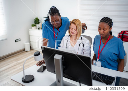 Medical team collaborating on computer healthcare information 140351209