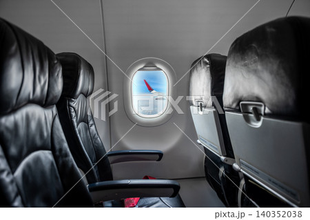 Airplane cabin interior, empty comfortable passenger seats in economy class with portholes. Airplane cabin interior, empty comfortable passenger seats in economy class with portholes. 140352038