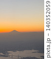 飛行機の窓から望む夕暮れの富士山と海岸線、街の風景② 140352059