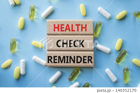 Health check reminder symbol. Concept words Health check reminder on wooden blocks. Beautiful blue background with pills. Healthcare and Health check reminder concept. Copy space. Health check reminder symbol. Concept words Health check reminder on wooden blocks. Beautiful blue background with pills. Healthcare and Health check reminder concept. Copy space. 140352170