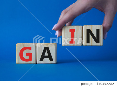Gain symbol. Concept word Gain on wooden cubes. Businessman hand. Beautiful blue background. Business and Gain concept. Copy space. 140352282