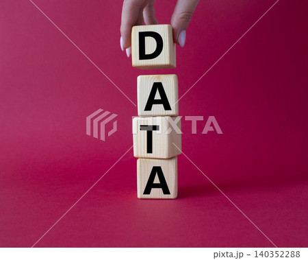 Data symbol. Concept word Data on wooden cubes. Businessman hand. Beautiful red background. Business and Data concept. Copy space. Data symbol. Concept word Data on wooden cubes. Businessman hand. Beautiful red background. Business and Data concept. Copy space. 140352288