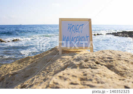 Project Management symbol. White blackboard with Concept words Project Management. Beautiful sea background. Business and Project Management concept. Copy space. Project Management symbol. White blackboard with Concept words Project Management. Beautiful sea background. Business and Project Management concept. Copy space. 140352325