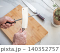 Sharpening a kitchen knife with a honing rod 140352757