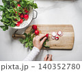 Hands slicing fresh red radishes 140352780
