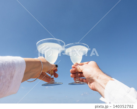 Two hands holding glasses of drink Two hands holding glasses of drink 140352782