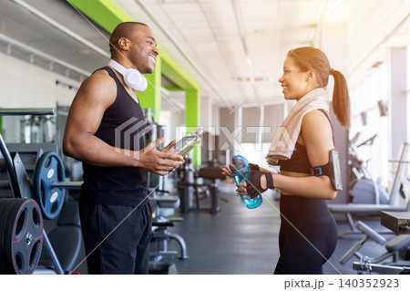 Young black talking and smiling after workout session in modern gym Young black talking and smiling after workout session in modern gym 140352923