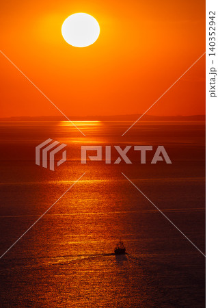Boat beneath bright sun over calm sea at bright sunset Boat beneath bright sun over calm sea at bright sunset 140352942