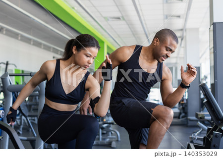 Young black fitness performing dynamic warm up exercises in modern gym Young black fitness performing dynamic warm up exercises in modern gym 140353029