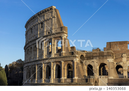 Famous Coliseum in Rome. Colosseum, or Coliseum. Sunset at huge Roman amphitheatre, Rome, Italy, Europe. Famous touristic place in the world and Europe. Beautiful blue sky background. Famous Coliseum in Rome. Colosseum, or Coliseum. Sunset at huge Roman amphitheatre, Rome, Italy, Europe. Famous touristic place in the world and Europe. Beautiful blue sky background. 140353088