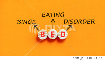 BED binge eating disorder symbol. Concept words BED binge eating disorder on beautiful wooden circles. Beautiful orange background. Medical BED binge eating disorder concept. Copy space. 140353154