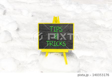 Tips and tricks words symbol. Concept words Tips and tricks on beautiful black blackboard. Beautiful white snow background. Business tips and tricks motivational support concept. Copy space. 140353176
