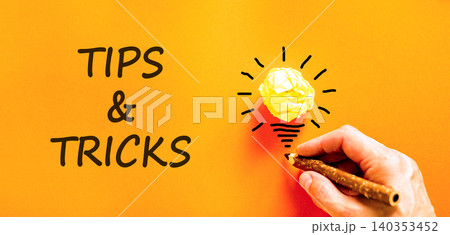 Tips and tricks words symbol. Concept words Tips and tricks on beautiful orange paper. Beautiful orange background. Businessman hand. Business tips and tricks motivational support concept. Copy space. Tips and tricks words symbol. Concept words Tips and tricks on beautiful orange paper. Beautiful orange background. Businessman hand. Business tips and tricks motivational support concept. Copy space. 140353452
