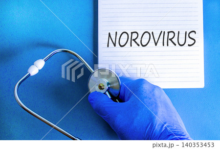 Norovirus medical words symbol. Concept words Norovirus on beautiful white note. Beautiful blue background. Doctor hand in blue medical glove. Stethoscope. Medical Norovirus concept. Copy space. 140353453