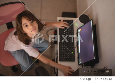 Child works on computer at home desk during the afternoon Child works on computer at home desk during the afternoon 140353938