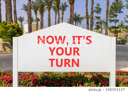 Now it's your turn words symbol. Concept words Now it's your turn on beautiful white road sign. Beautiful palm trees background. Business Now it's your turn motivational support concept Copy space Now it's your turn words symbol. Concept words Now it's your turn on beautiful white road sign. Beautiful palm trees background. Business Now it's your turn motivational support concept Copy space 140354137