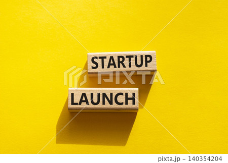Startup launch symbol. Concept word Startup launch on wooden blocks. Beautiful yellow background. Business and Startup launch concept. Copy space Startup launch symbol. Concept word Startup launch on wooden blocks. Beautiful yellow background. Business and Startup launch concept. Copy space 140354204