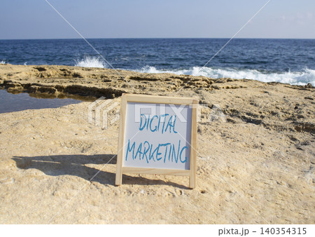 Digital Marketing symbol. White blackboard with Concept words Digital Marketing. Beautiful sea background. Business and Digital Marketing concept. Copy space. Digital Marketing symbol. White blackboard with Concept words Digital Marketing. Beautiful sea background. Business and Digital Marketing concept. Copy space. 140354315