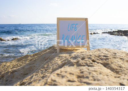 Life Balance symbol. White blackboard with Concept words Life Balance. Beautiful sea background. Business and Life Balance concept. Copy space. Life Balance symbol. White blackboard with Concept words Life Balance. Beautiful sea background. Business and Life Balance concept. Copy space. 140354317