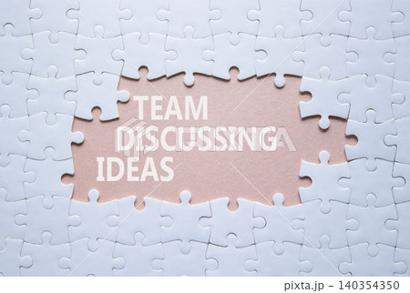 Team Discussing Ideas symbol. White puzzle with words Team Discussing Ideas. Beautiful pink background. Business concept. Copy space. Team Discussing Ideas symbol. White puzzle with words Team Discussing Ideas. Beautiful pink background. Business concept. Copy space. 140354350