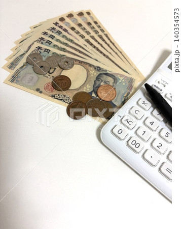 扇形に広げた日本の新紙幣と硬貨と電卓 140354573