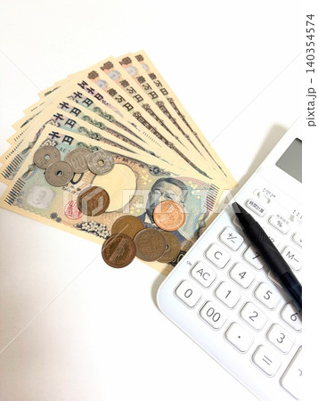 新紙幣と硬貨と電卓とペンの家計イメージ 140354574