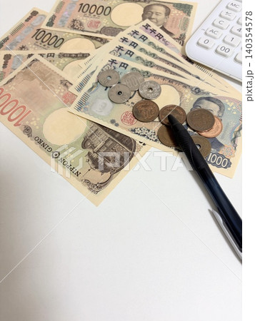 一万円札と千円札と小銭と電卓とペン 一万円札と千円札と小銭と電卓とペン 140354578