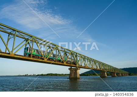 徳島県の高徳線の佐古駅と吉成駅の間にある吉野川橋梁を走る普通列車 140354836