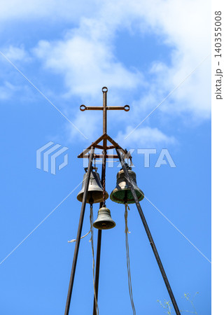 Old church bells and cross against blue sky Old church bells and cross against blue sky 140355008