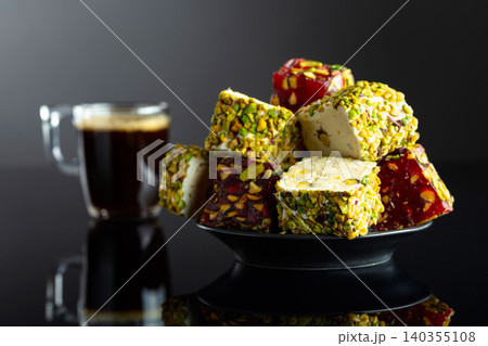 Turkish delights and black coffee on a black reflective background. Turkish delights and black coffee on a black reflective background. 140355108