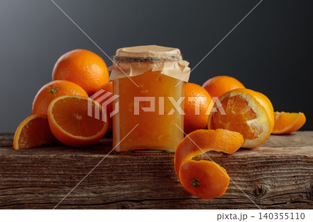 Homemade orange jam in a glass jar on on a black background. 140355110