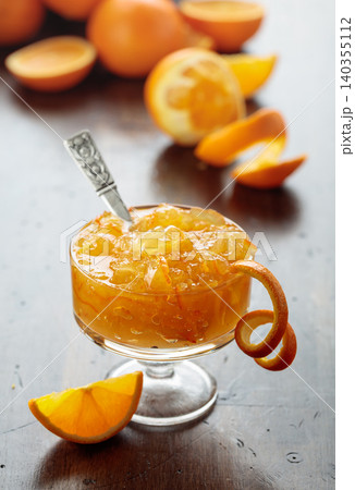 Orange jam in a glass dessert bowl on an old wooden table. Orange jam in a glass dessert bowl on an old wooden table. 140355112