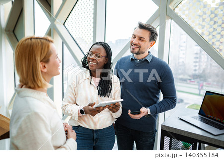 Diverse coworkers collaborating in office with digital tablet 140355184