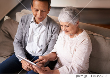 Senior, couple and happiness with tablet on sofa for online bingo, crossword puzzle or internet games in living room. Elderly, man and woman with face or top view with technology for web news in home 140355208