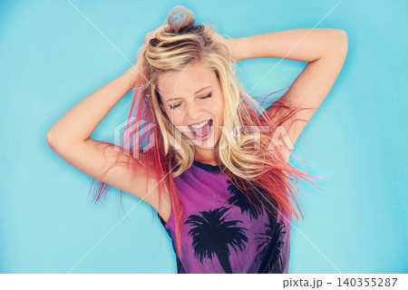 Woman, playful and comic or happy in studio, having fun and excited with energy on blue background. Female person, hair and casual aesthetic for gen z culture, laughing and crazy girl on backdrop 140355287