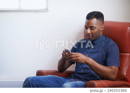 Man, phone and relax on social media at home, online and internet for website or blogging. Black male person, typing and streaming entertainment on armchair, texting and app for shopping on weekend 140355360
